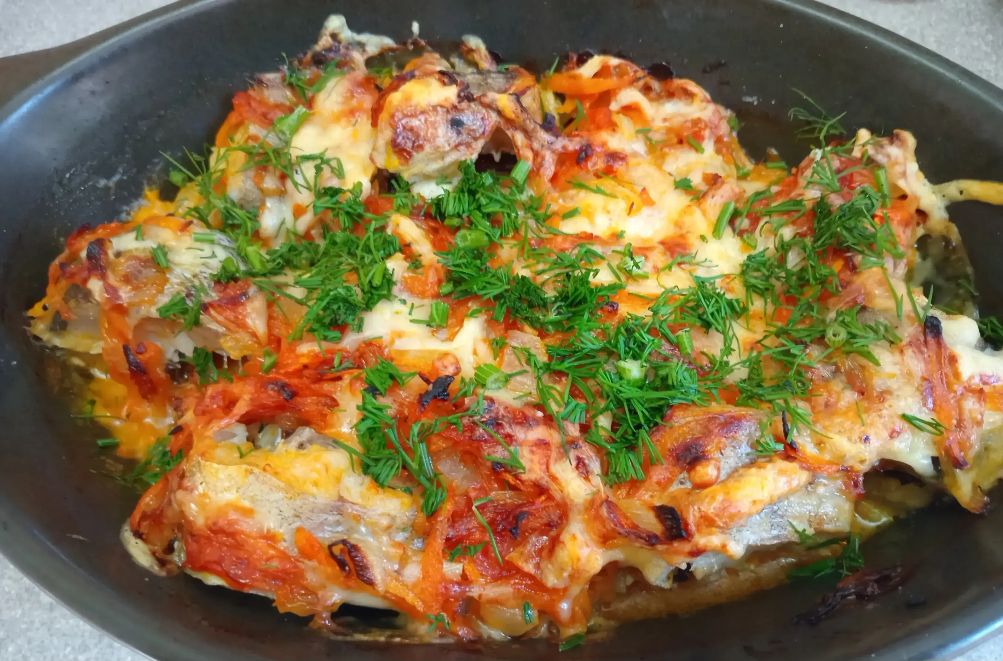 Минтай запечённый с луком, морковью и сыром