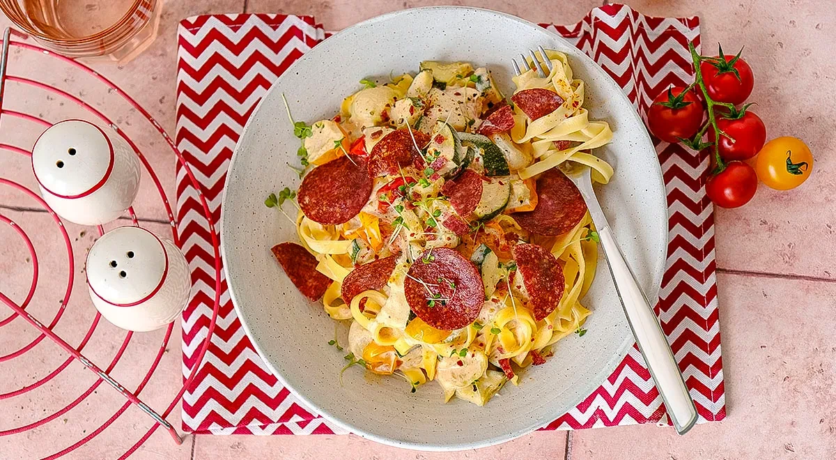 Паста с овощами и чипсами из салями